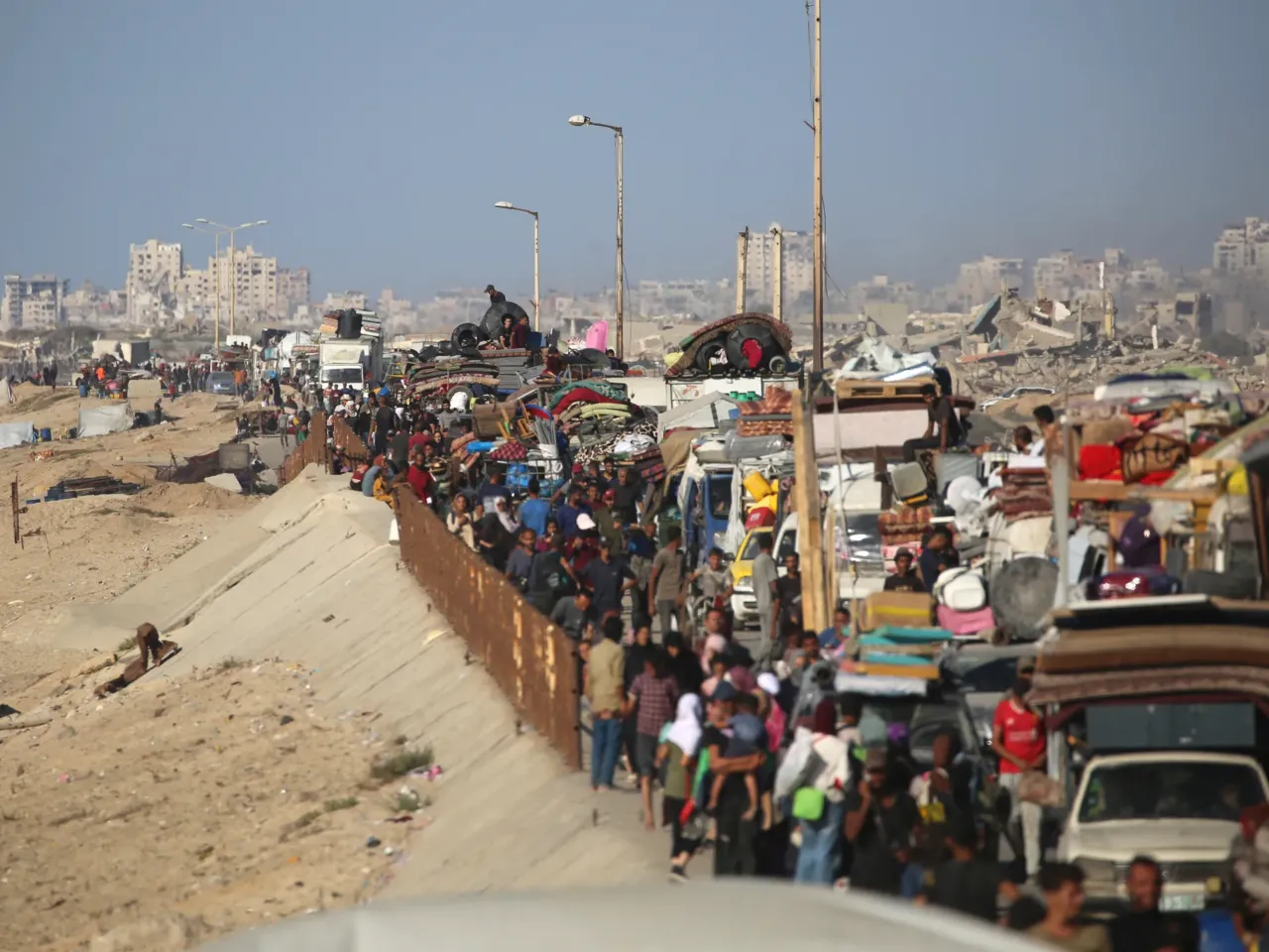 Displaced Palestinians move with their belongings southwards on a road in the Nuseirat refugee camp area in the central Gaza Strip following renewed Israeli evacuation orders for Gaza City on September 16, 2025.