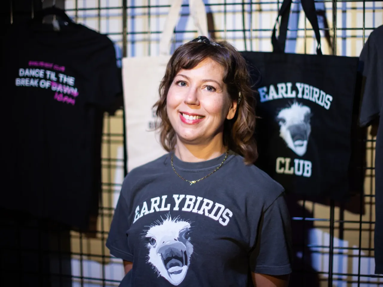 Laura Baginski, co-founder of Earlybirds Club, stands next to merchandise at the start of the event.
