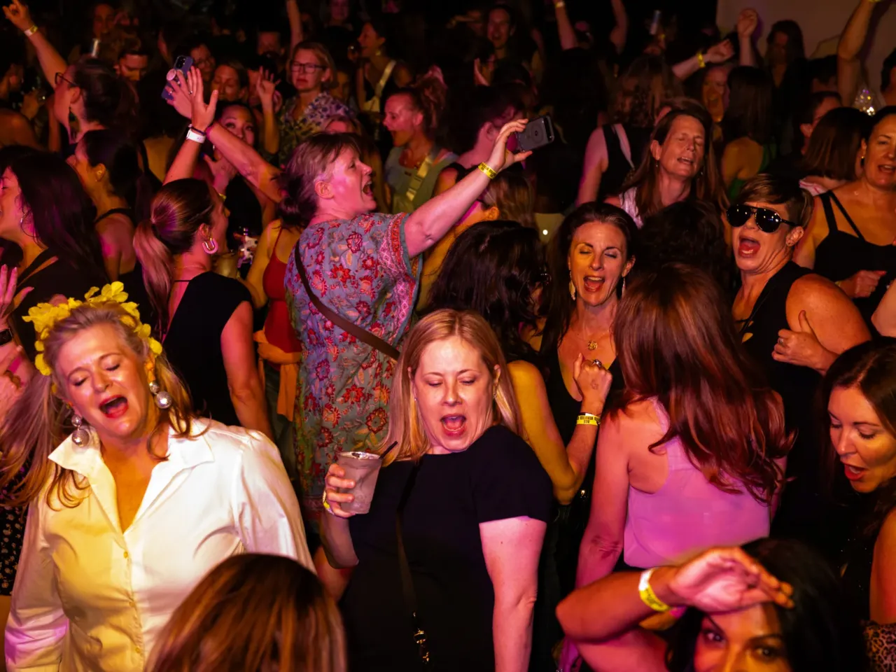 Partygoers sing along to the music while on the dance floor.