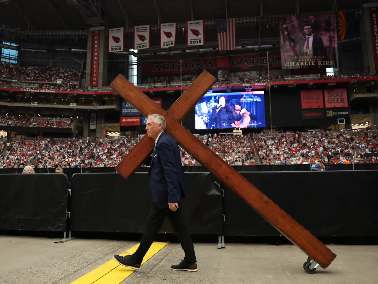 A large cross is wheeled in ahead of the public memorial service for right-wing activist Charlie Kirk.