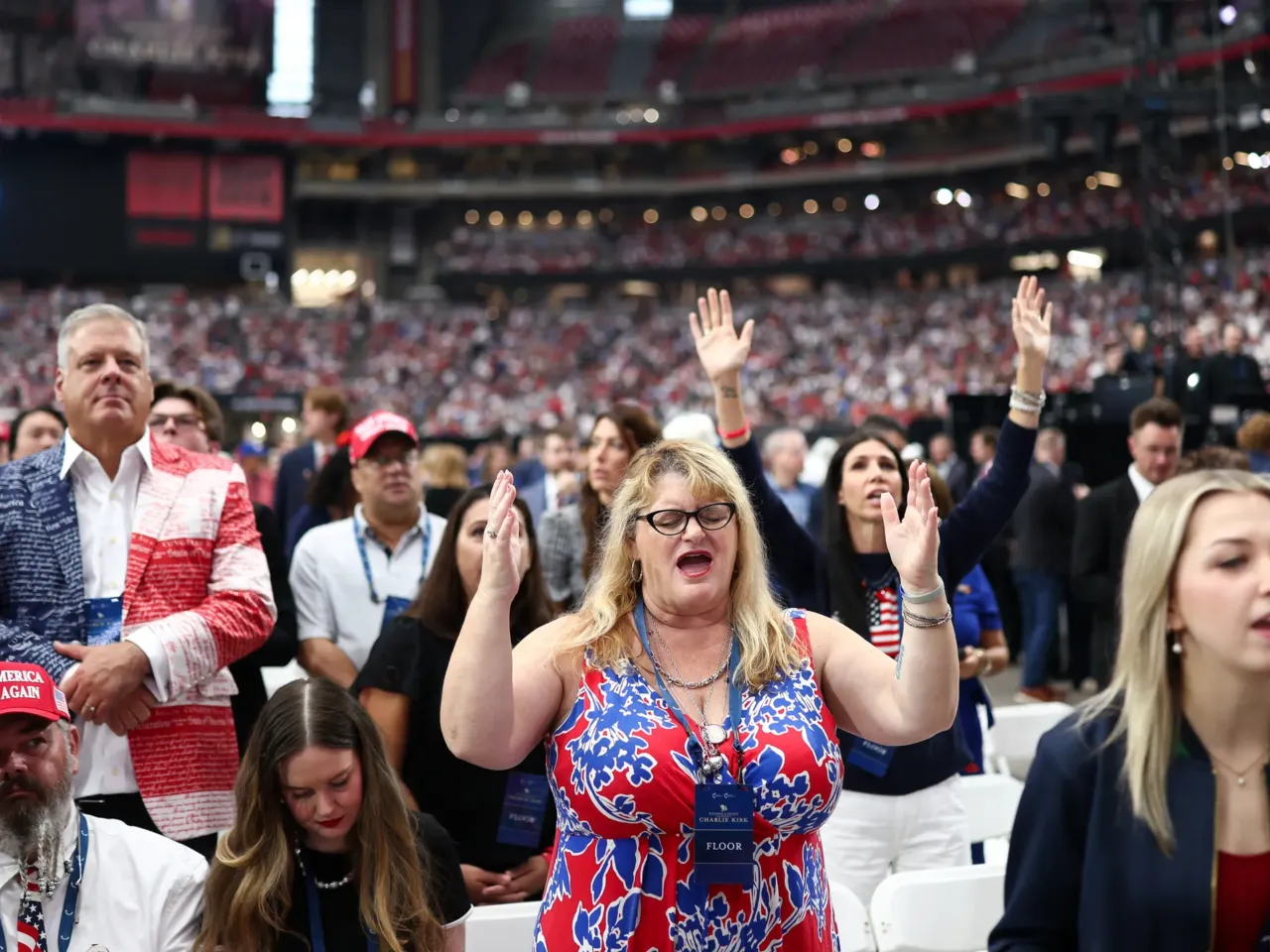People pray before the start of the public memorial service for Charlie Kirk.