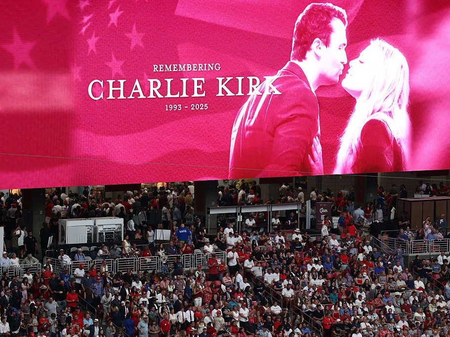 A banner shows Charlie Kirk and his wife Erika, who was named the new CEO of Turning Point USA.
