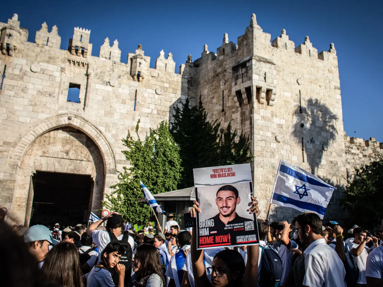 The costs of Israel's longest war, for Israelis 1 An Israeli woman holds up a placard showing a photo of Rom Braslavsky, who is held hostage by Hamas in Gaza, outside Damascus Gate in Jerusalem.