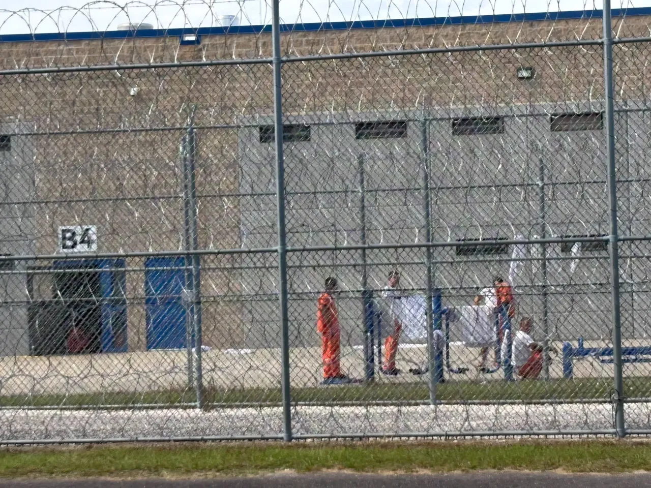 The price of a paycheck: one town's ICE dilemma 1 Detainees spend time outdoors behind barbed wire, as seen from a sandy public road that runs behind the facility.