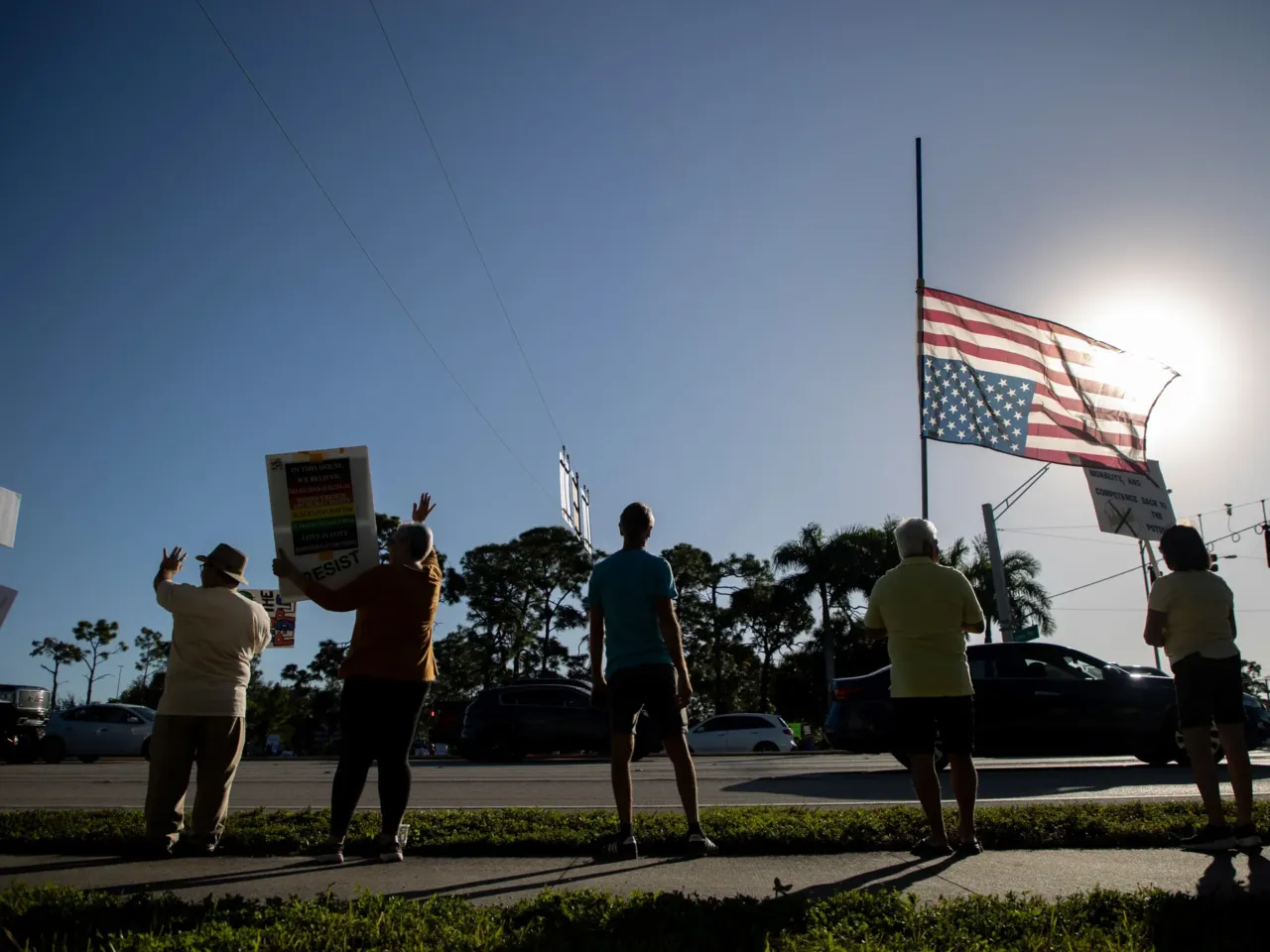 Demonstrators holding signs and an upside-down American flag as a signal of distress in Fort Myers, Florida.