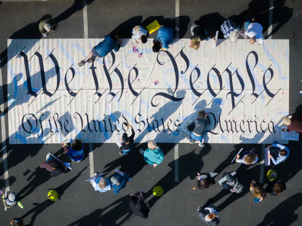 Protestors sign a "We the People" banner in Hartford, CT.