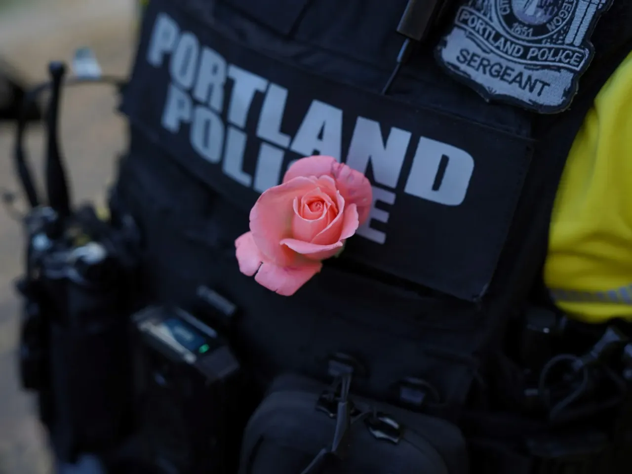 A Portland police officer with a rose on their uniform at the "No Kings 2.0" rally in Portland, Ore., on Oct. 18, 2025.
