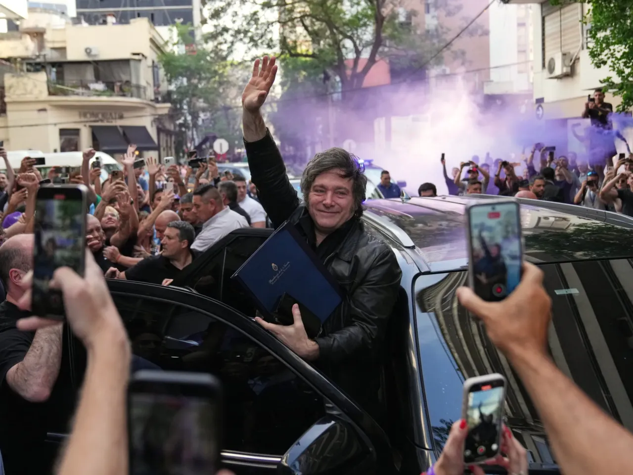Argentine President Javier Milei waves to supporters upon arriving at a hotel in Rosario, Argentina, Thursday.