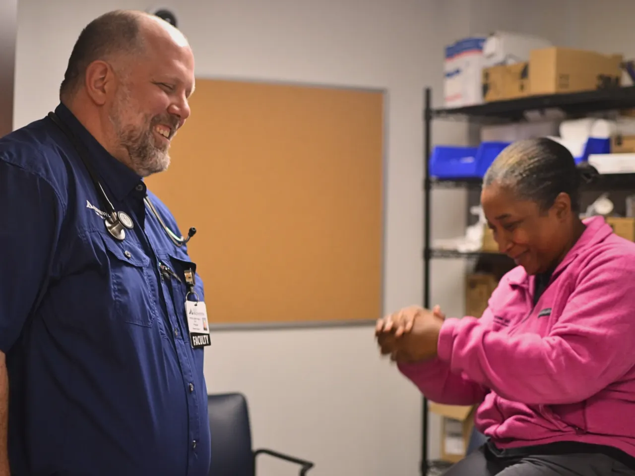 Dr. Brent Smith, left, a physician at a primary care clinic at Delta Health System in Greenville, Miss. laughs with a co-worker.