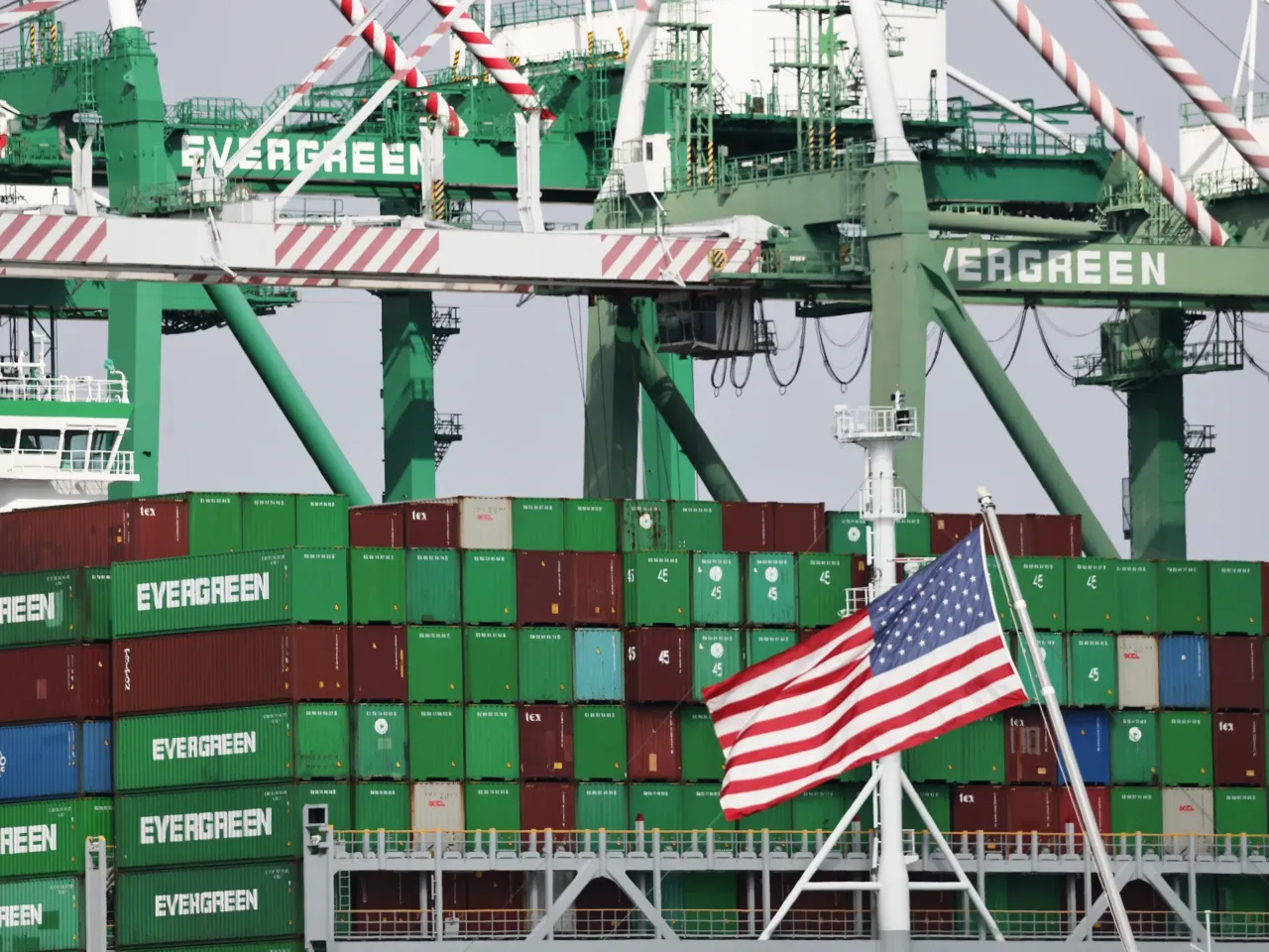 An American flag flies near shipping containers at the Port of Los Angeles on Sept. 26.