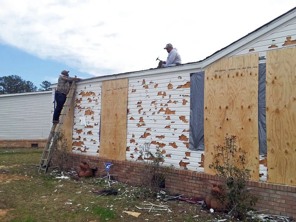 It's harder to get home insurance. That's changing communities across the U.S. 3 John Purry secures tarps on the roof of his house in Pearl, Miss., after a hailstorm in 2013. In 2024, hailstorms caused an estimated $160 billion in damage to homes nationwide, according to the Insurance Information Institute, an industry-run think tank.