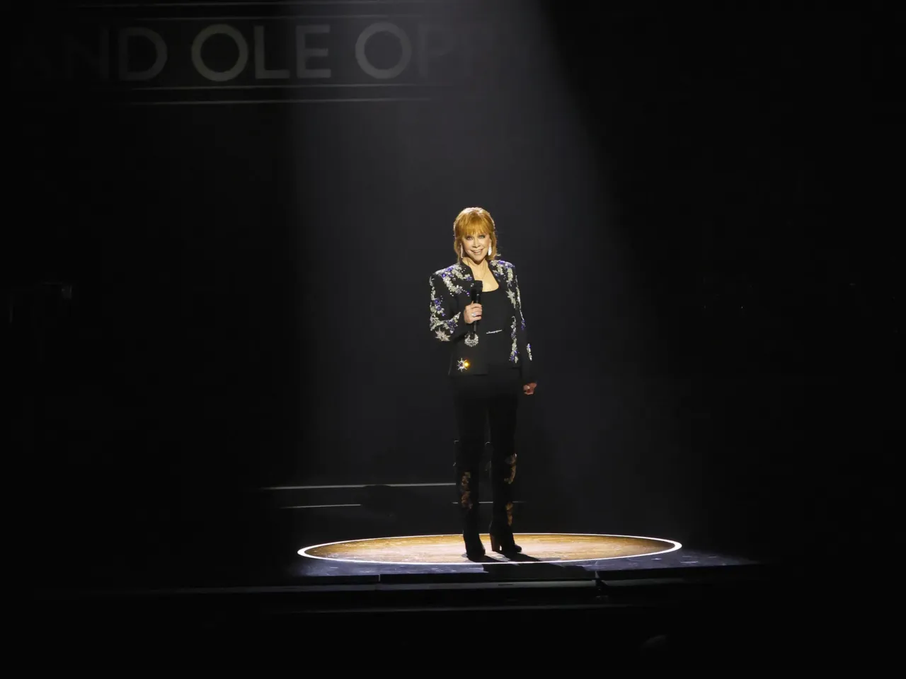 Reba McEntire stands in the circle cut from the stage of the Grand Ole Opry's early home, the Ryman Theater, during a celebration of the Opry's centennial in March, 2025.