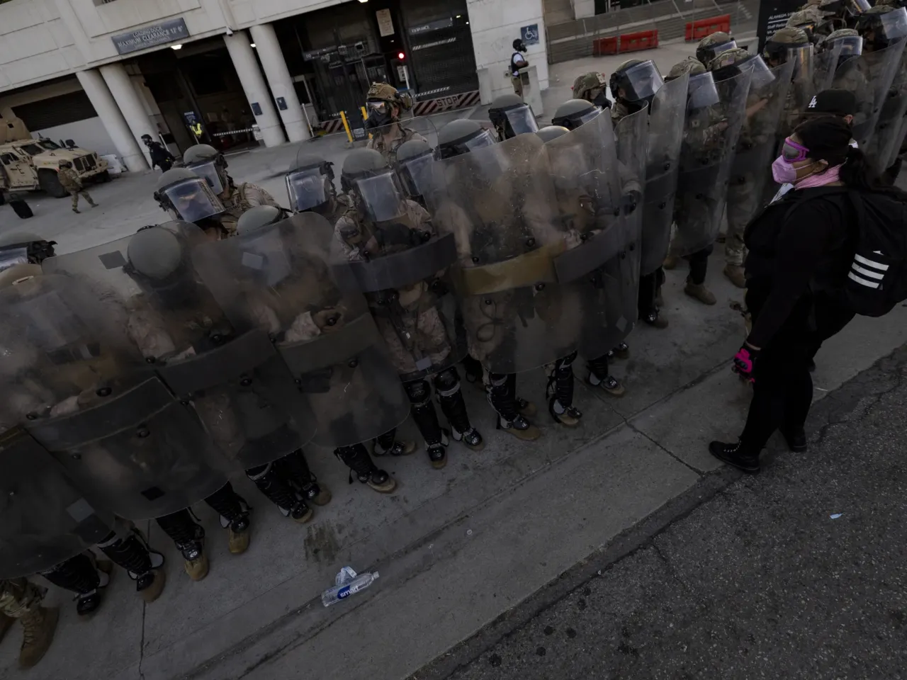 U.S. Marines and National Guard troops patrol the entrance of the Metropolitan Detention Center in Los Angeles as demonstrators gather on July 4, 2025.