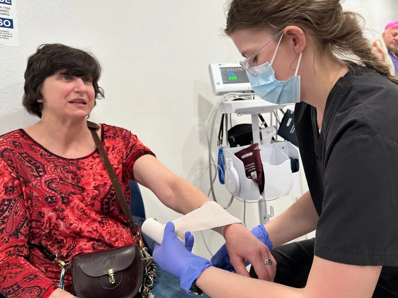 On-site emergency medical technician Emily Woolsey wraps the swollen wrist of MVP shelter resident Jamie Mangum after a fall. Mangum says that in other shelters, she would likely have had to find her own way to an urgent care office to get treatment. She credits the shelter for helping her deal with all her medical issues.