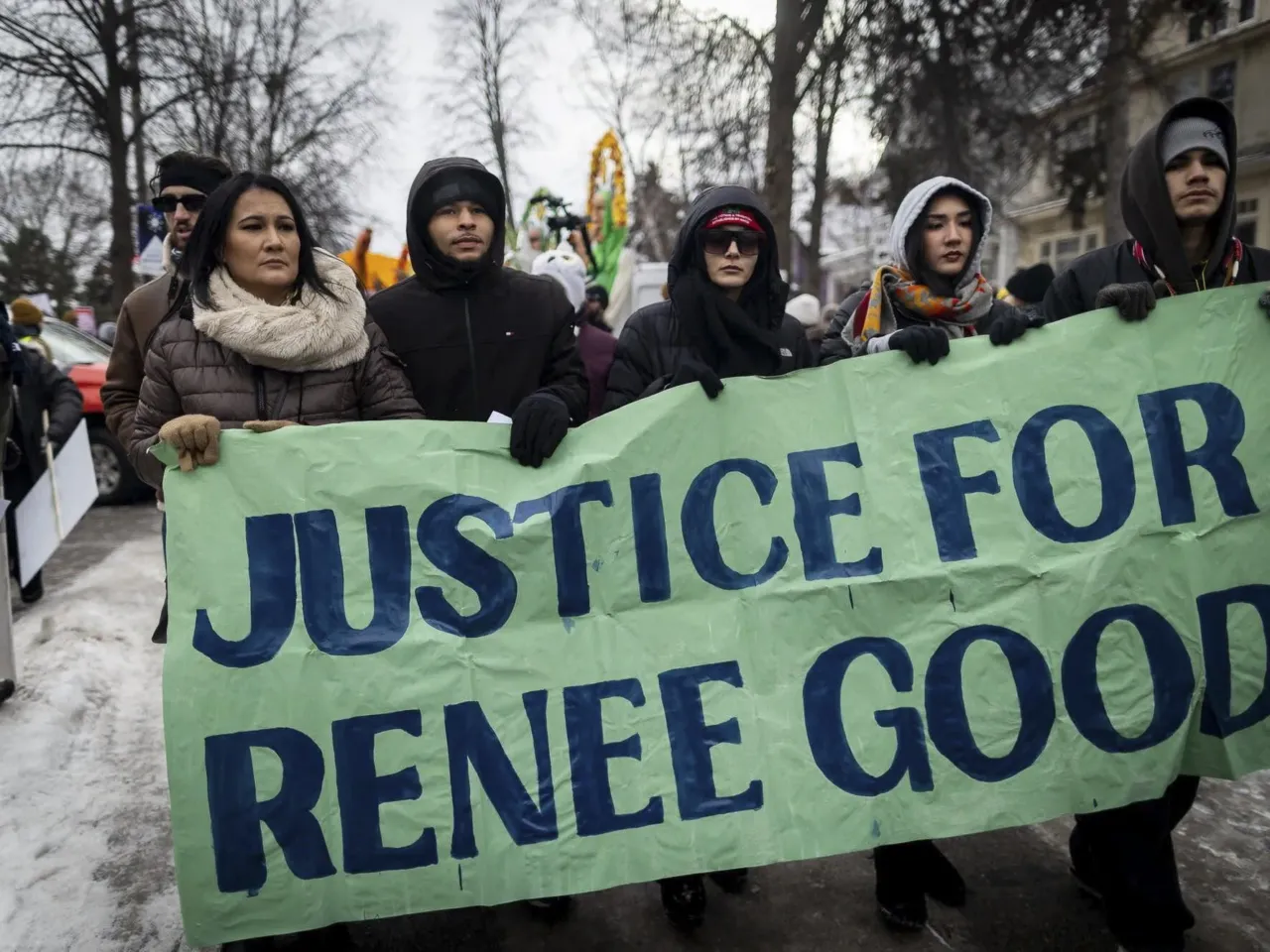 Demonstrators hold a banner calling for justice for Renee Good, who was shot and killed by an ICE agent on Jan. 7, during a rally in Minneapolis on Saturday, Jan. 10, 2026.