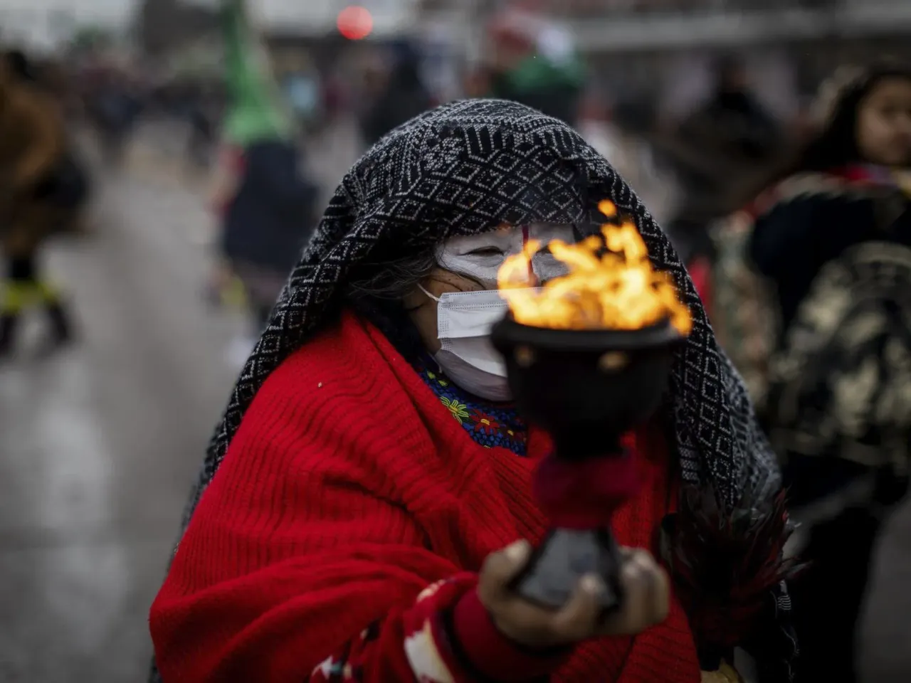 A woman holds a chalice of burning sage as thousands of demonstrators march down Lake Street in Minneapolis during a rally to demand ICE's removal from Minnesota on Saturday, Jan. 10, 2026.