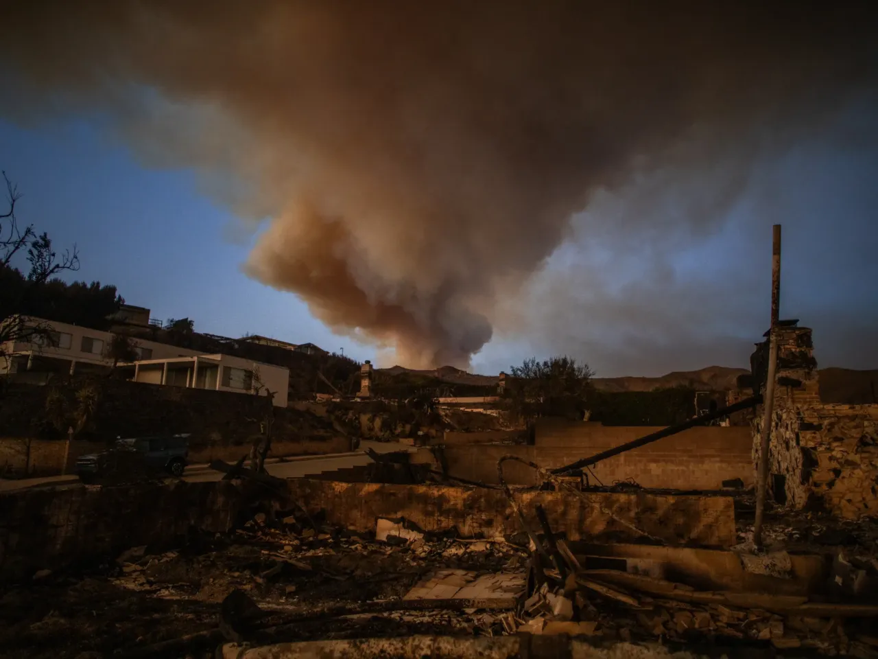Wildfire smoke towered over burned houses from the Palisades Fire on January 10, 2025. The fires burned for days, blanketing the region in toxic smoke. The health effects are just beginning to become clear.