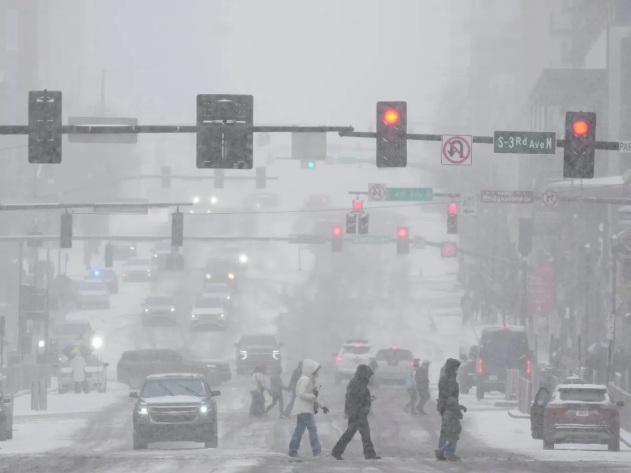 Pedestrians cross the street along Broadway during a winter storm Saturday, Jan. 24, 2026, in Nashville, Tenn.