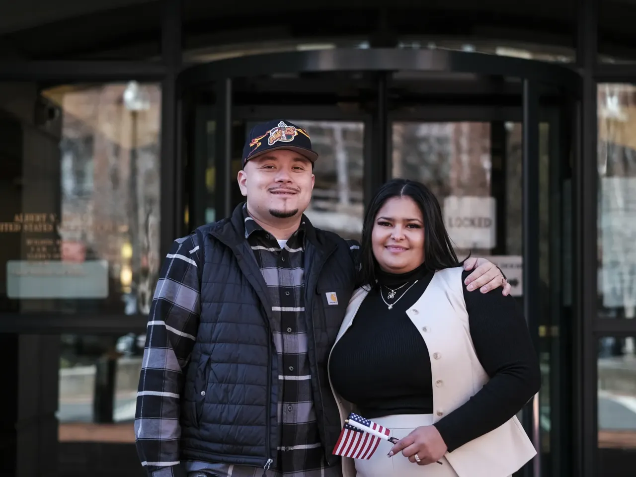 Ashley Lezama (right), of Honduras, stands with her husband, Nick Moreno, of Bolivia following her naturalization ceremony in Alexandria, Va.
