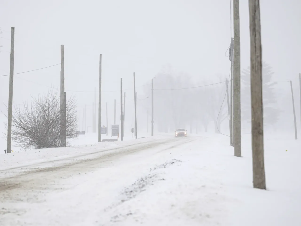Power outages and canceled flights as winter storm brings snow, sleet and ice 1 A vehicle drives through snowy conditions on Sunday in Louisville, Ky.