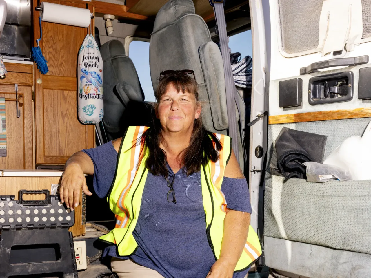 Home on Wheels Alliance staff member Tracey Power sits on the edge of her van.