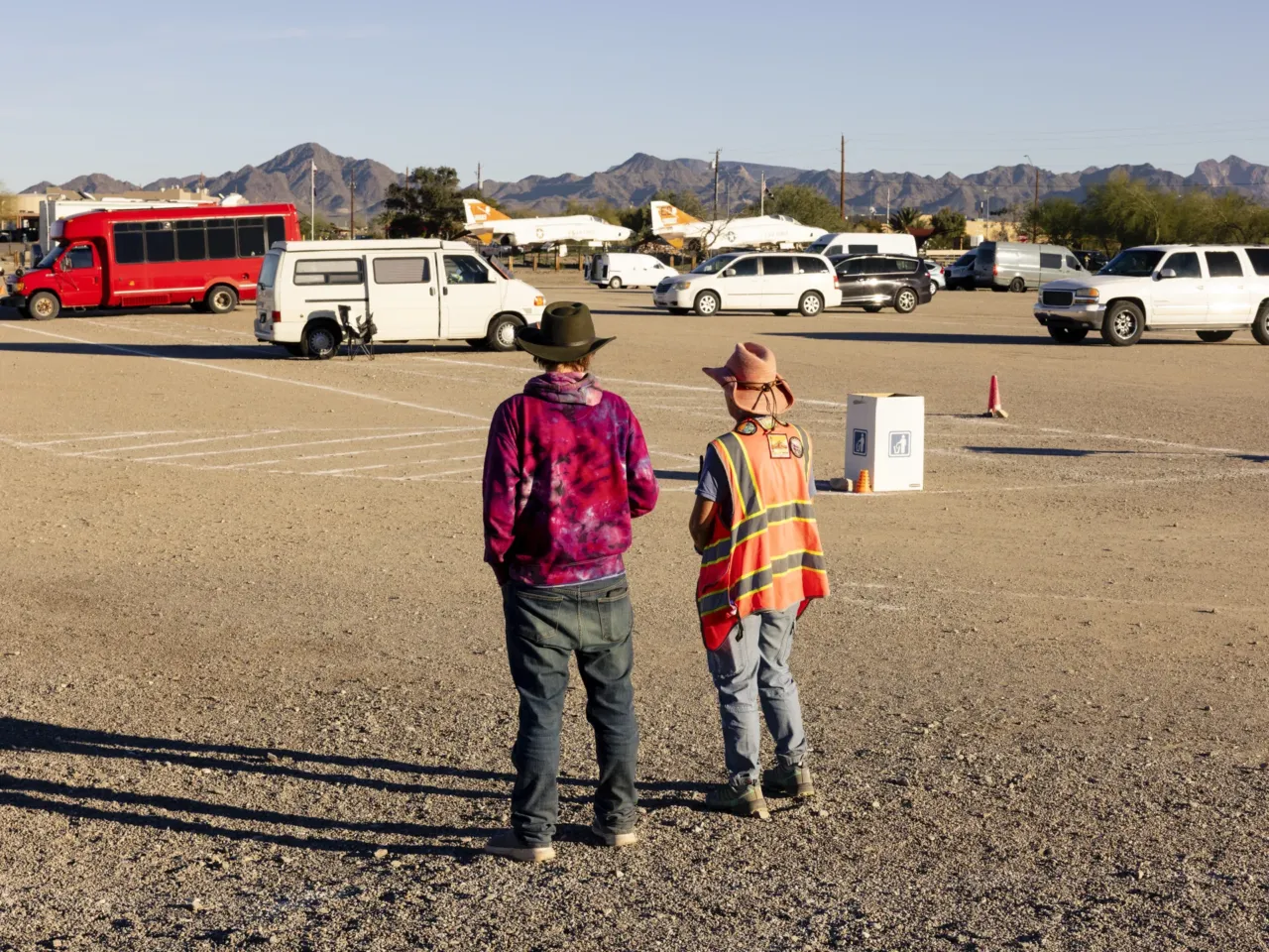 Two volunteers talk at the end of the day of the Rubber Tramp Rendezvous, an annual meetup of nomads who live in their vehicles, in Quartzsite, Ariz., on Jan. 13.