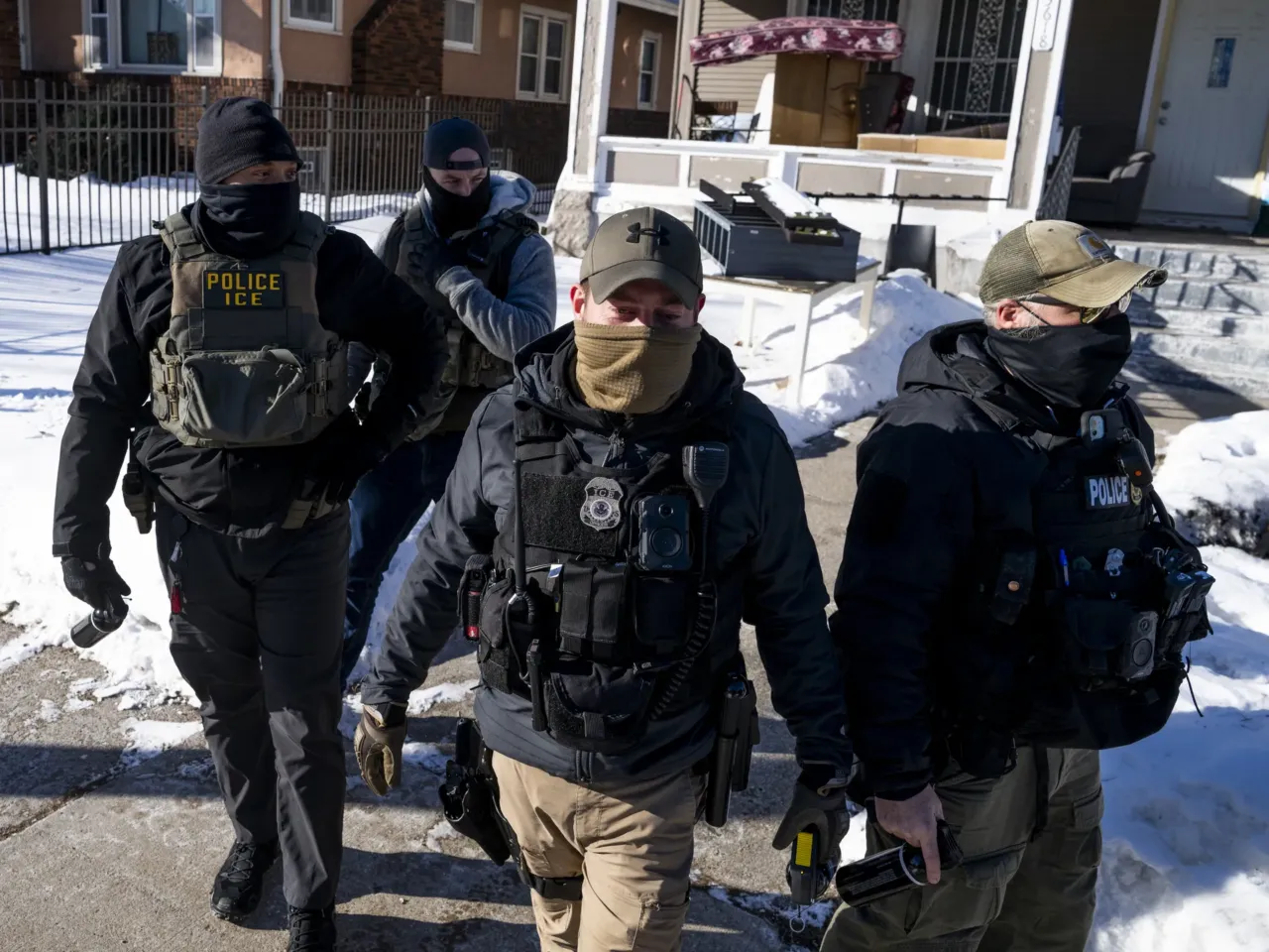 DHS keeps making false claims about people. It's part of a broader pattern 2 Masked ICE agents leave a residence after knocking on the door in Minneapolis on Wednesday.