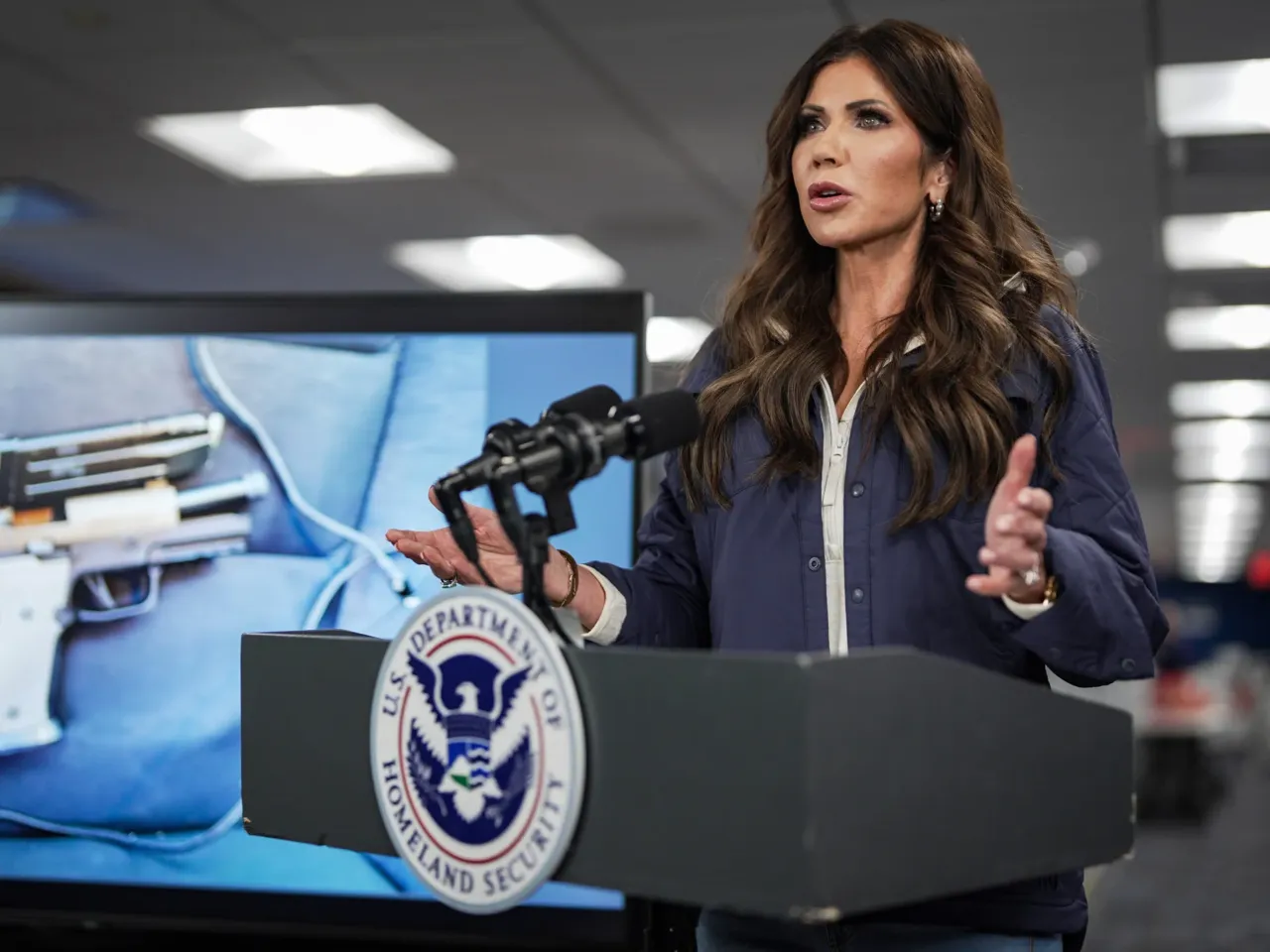 A photograph of the pistol recovered by immigration agents after a shooting in Minneapolis is shown on a screen behind U.S. Secretary of Homeland Security Kristi Noem as she speaks during a news conference in Washington, D.C., on Jan. 24. Federal immigration agents shot and killed Alex Pretti that day during operations in Minneapolis.
