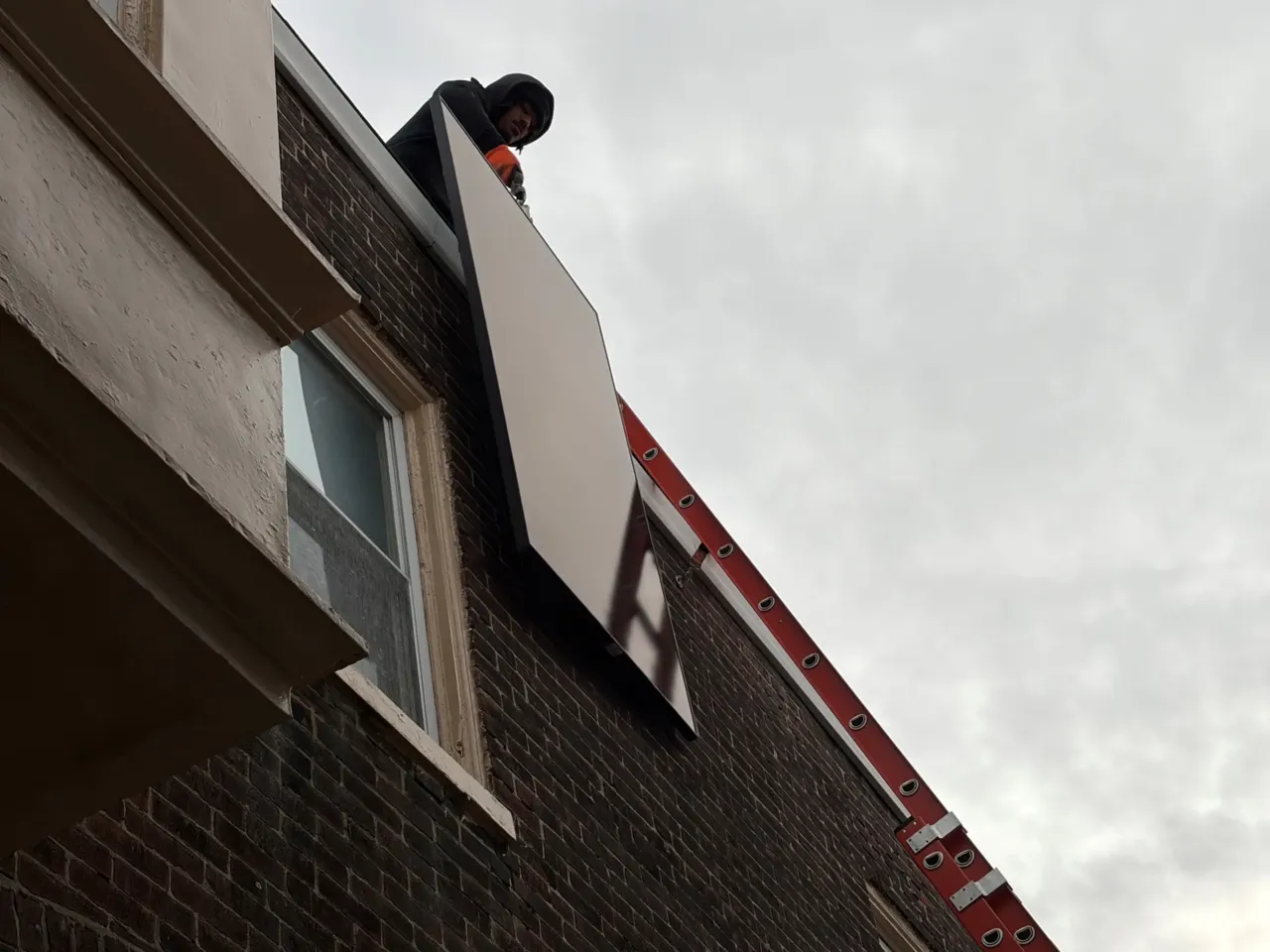 Tax credits for solar panels are available, but the catch is you can't own them 1 A Solar States installation crew hoists a solar panel onto the roof of a Philadelphia home.