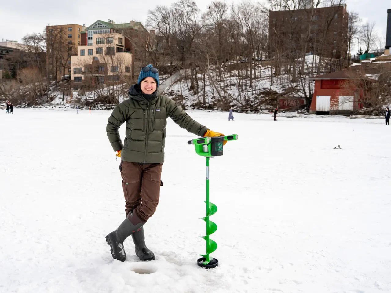 This community festival embraces the joys of a frozen lake — while it still has one 1 Hilary Dugan, a limnologist at the University of Wisconsin, Madison, poses for a portrait behind a hole she drilled on Lake Mendota during the city's annual Frozen Assets Festival on Feb. 7.
