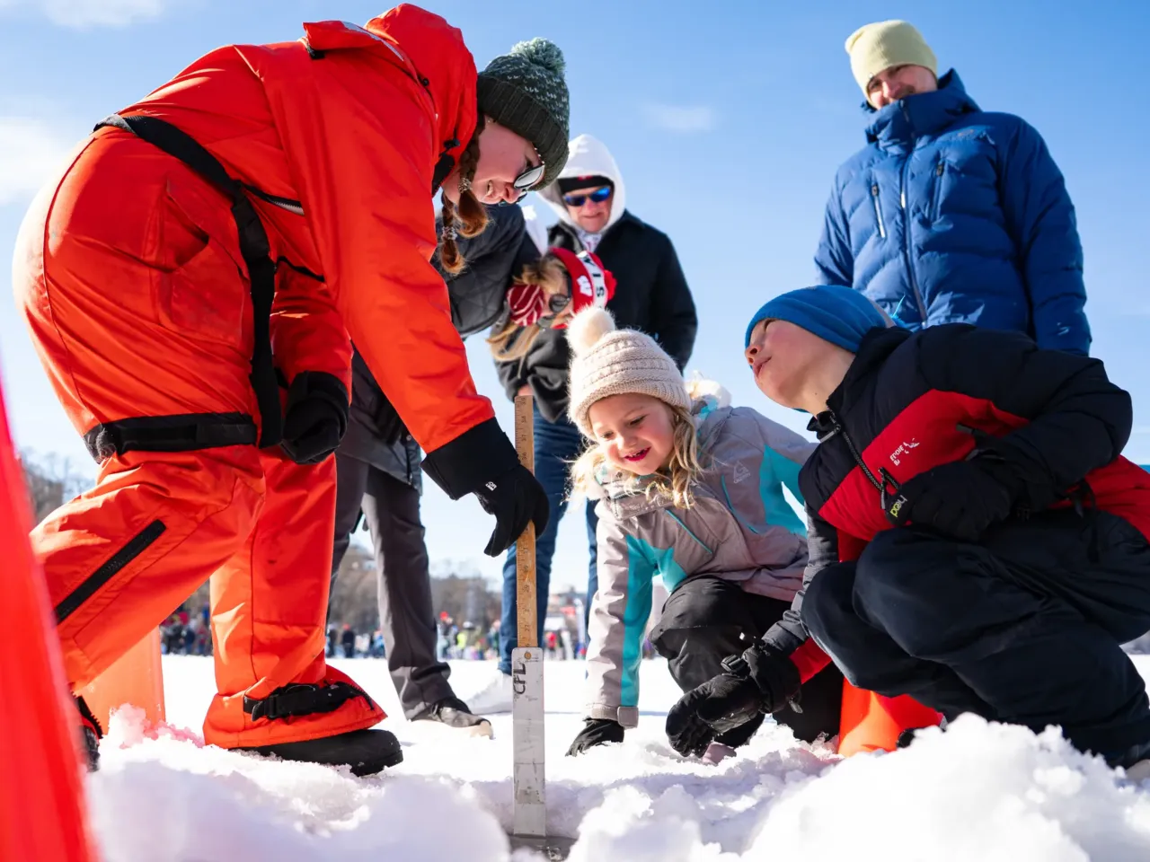 This community festival embraces the joys of a frozen lake — while it still has one 5 Lincoln Haldeman (right) and his sister Piper (center) measure ice thickness with Helen Schlimm (left), a researcher at UW-Madison's Center for Limnology, during a science demonstration at the annual Frozen Assets Festival on Lake Mendota on Saturday, Feb. 7.