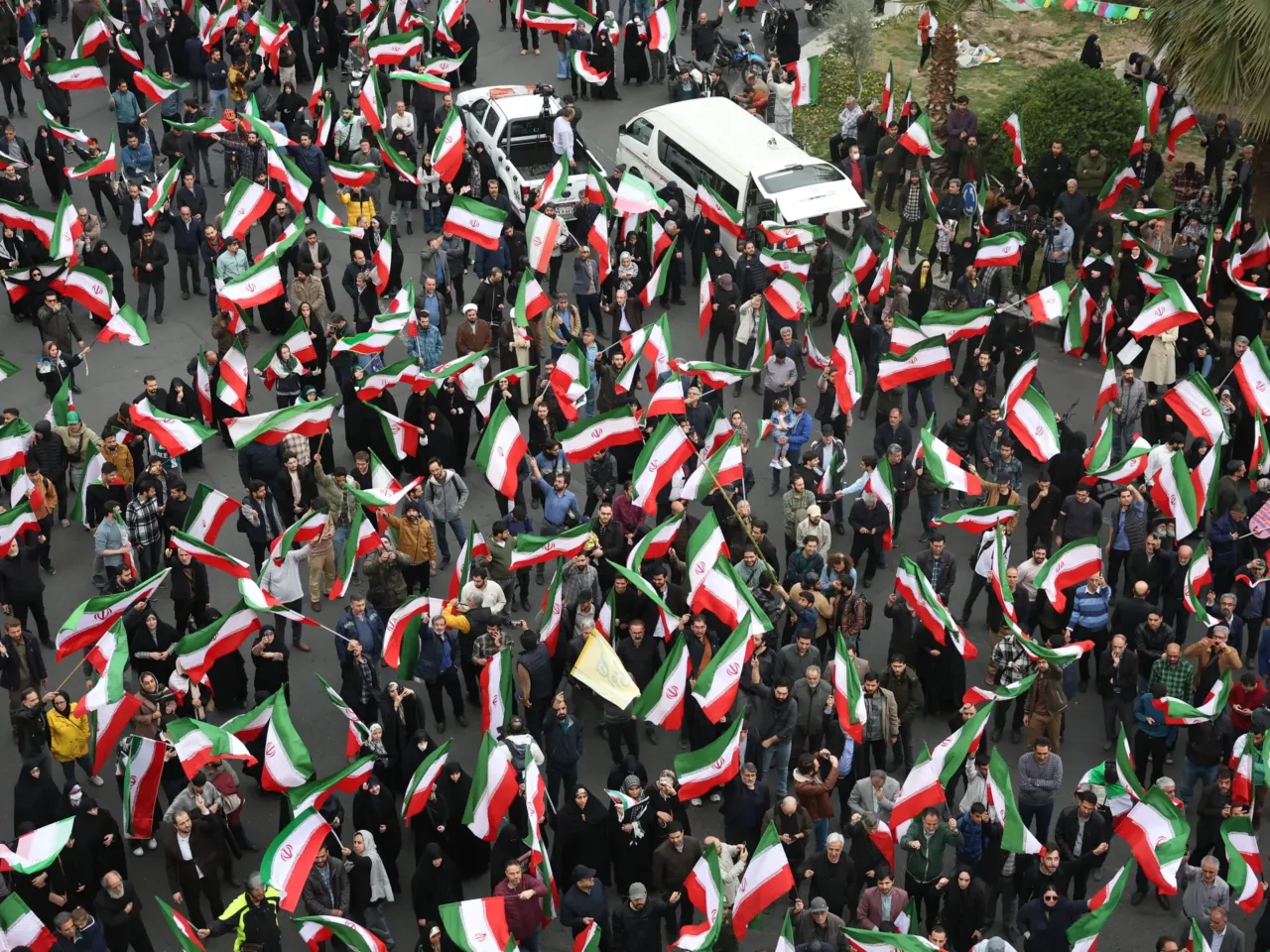 A group of demonstrators wave Iranian flags in support of the government and against U.S. and Israeli strikes in Tehran, Iran, Saturday, Feb. 28, 2026.