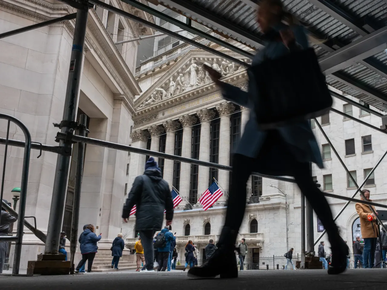 People walk by the New York Stock Exchange on Wall Street. Trades of tariff refunds have ballooned since the Supreme Court struck down many of President Trump's tariffs.