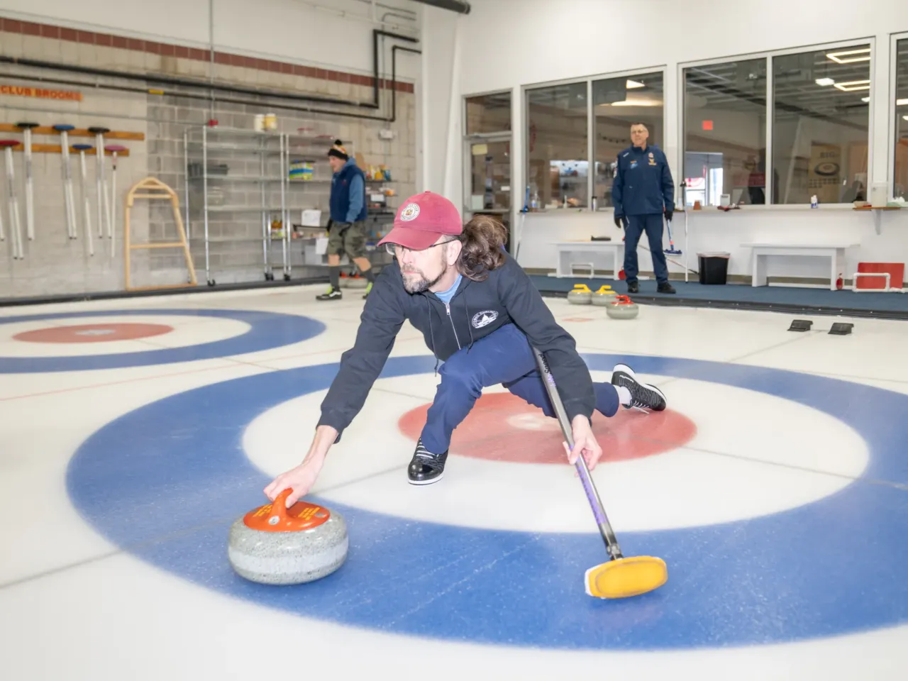 Ted Hallock delivers a rock during a curling game at the Potomac Curling Club in Laurel, Md. Curling clubs often see a boost in interest following the Winter Olympics.