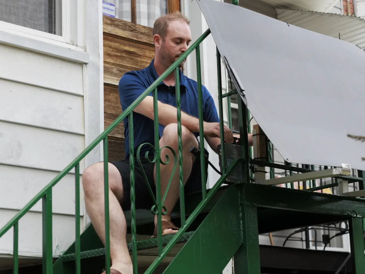 Craig Keenan installs a plug-in solar panel on his back steps last August in Baltimore.