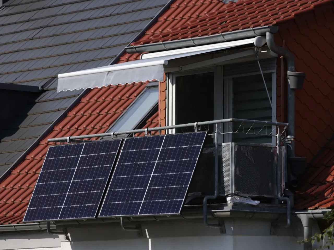 Solar energy panels hang from a residential apartment balcony in Erfurt, Germany. More than 1.2 million small plug-in solar systems are registered with the German government.