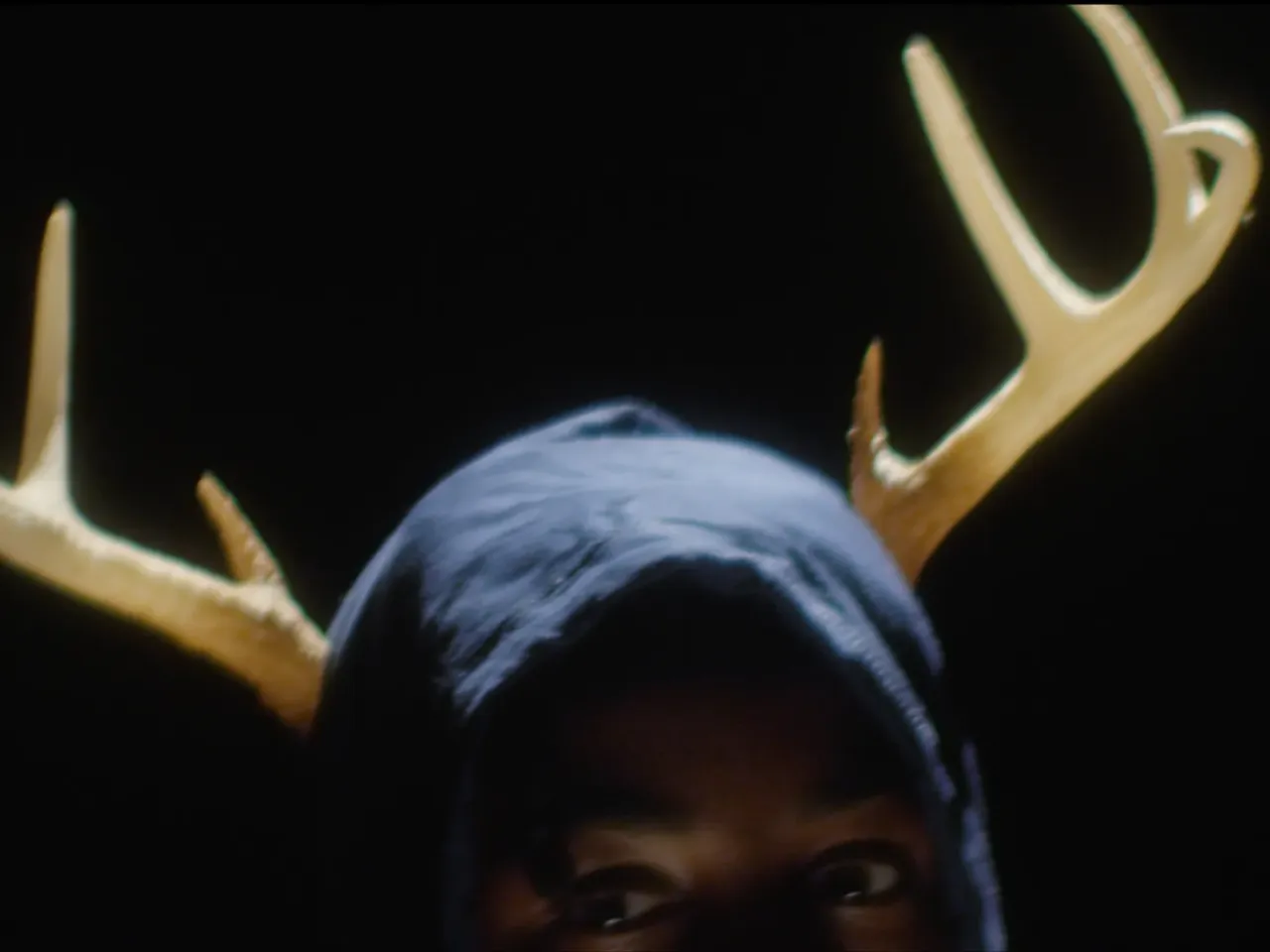 Actor Myles Lassiter, as "kid James," wears antlers in Songs from the Hole. Jacobs says it's the image he's asked about most often. "These antlers, along with being [for the song] 'Most Hunted,' are very gun-hunting, violent-culture — the experience, as a Black man, was that [Black men] were being hunted like deer, like buck in this country. And early references of Black men in this country — we were called Bucks. And so I thought — we [Jacobs and Gayles] thought — it was fitting ... that this character represented the coming-of-age through antlers and the symbolism of being hunted with antlers on his head."