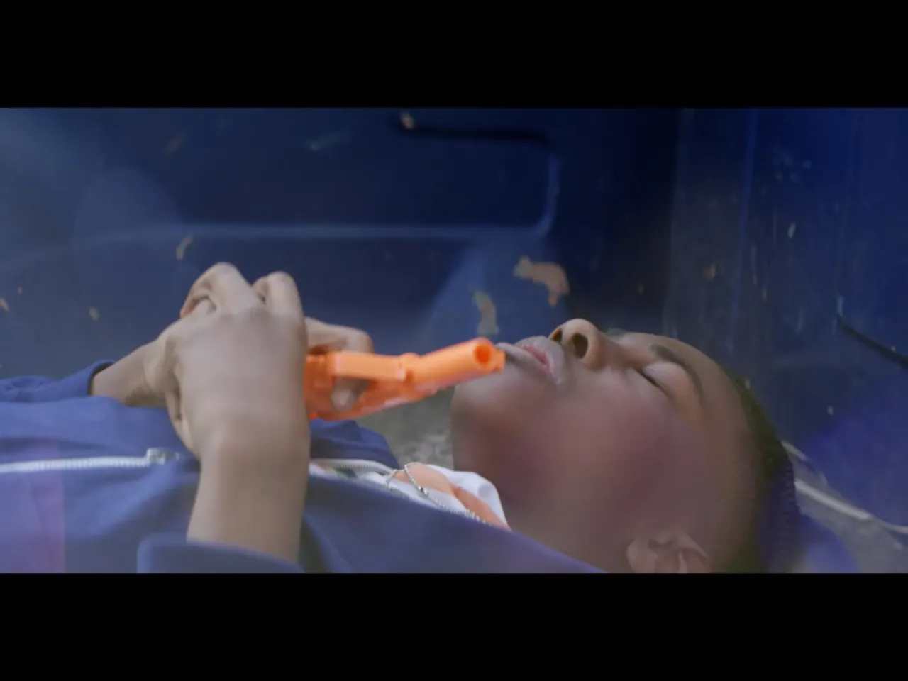 Actor Myles Lassiter portrays a young Jacobs lying in the bed of a pickup truck, holding a toy gun, during the song, "Most Hunted." Jacobs says the visual was important to him because "in the song itself, I mentioned ... a couple of references to 'Friday,' one of them being during the hook, 'the government launched four drones. Still, I need a Glock to walk Smoke home. I'm not a man with it. I'm a man without it.' And those lines kind of hint toward quotes from the film 'Friday,' which is where Craig [played by Ice Cube] is in the room with his father. He just discovered that his father just discovered that he owns a gun. And [his dad] says, 'Back in my day, we would use these [referencing his fists]. Are you a man or are you not?' And [Craig] says, 'I'm a man without it. I'm a man without this gun.' And I knew when I first saw that, that I was like, 'I'm a man without a gun, but in this world, they don't see a man unless I have a gun.'"
