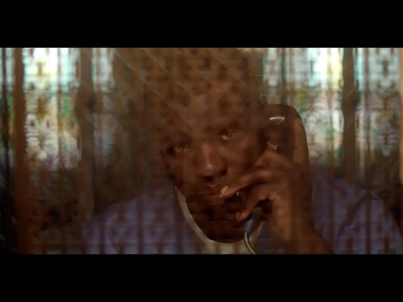 Hoy depicts an older Jacobs talking to his father through glass during a visitation. In the film, Jacobs says he had just finished writing two verses of his song "Steel Grave," and rapped both verses over the phone for his dad. When he finished, Jacobs says his father asked him, "What happens to the character? You just described he was in this dark world. Does he ever come out?"
