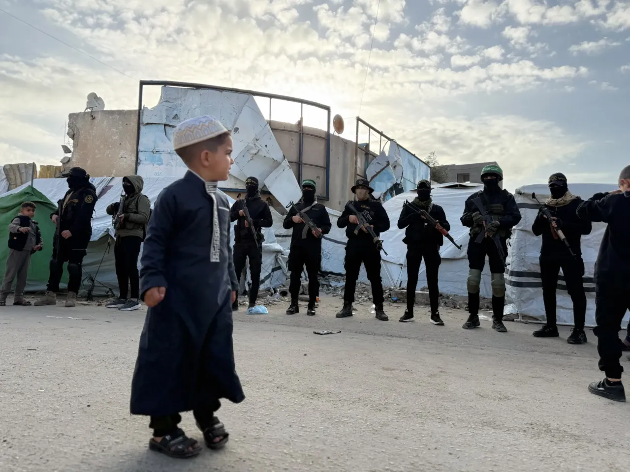 Palestinians celebrate Eid in Gaza, making the most of a fragile ceasefire 8 A boy looks at Hamas police on Eid in Gaza City.
