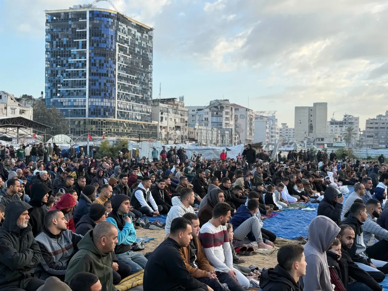 Palestinians celebrate Eid in Gaza, making the most of a fragile ceasefire 9 People listen to sermons outside, near destroyed and damaged buildings.