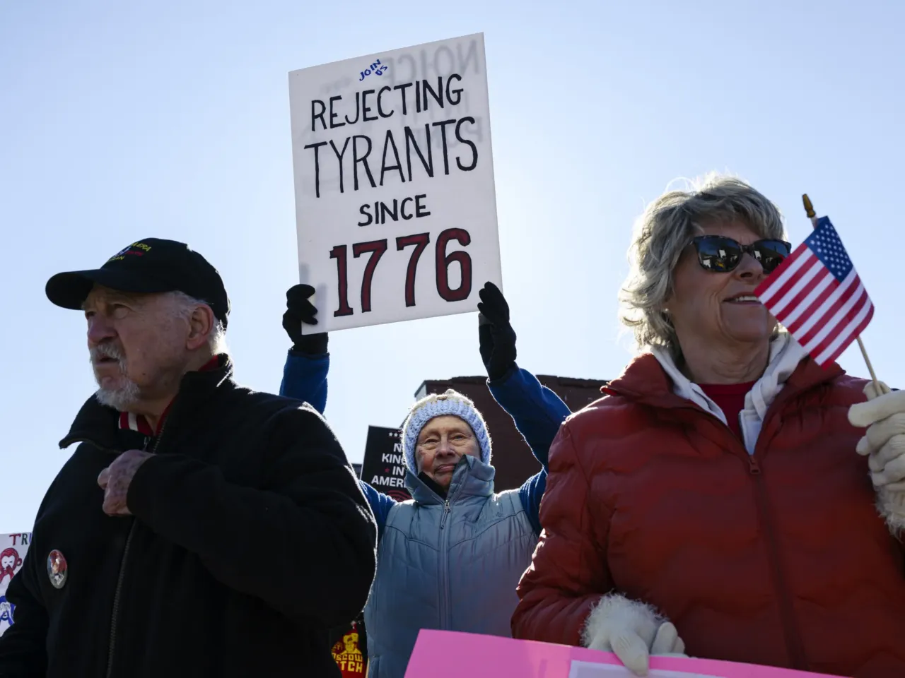 Demonstrators gather while holding signs near a roadside in Shelbyville, Kentucky.