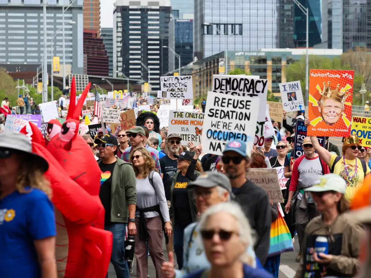 A large crowd marches across the South First bridge toward a gathering at Auditorium Shores in Austin, Texas.