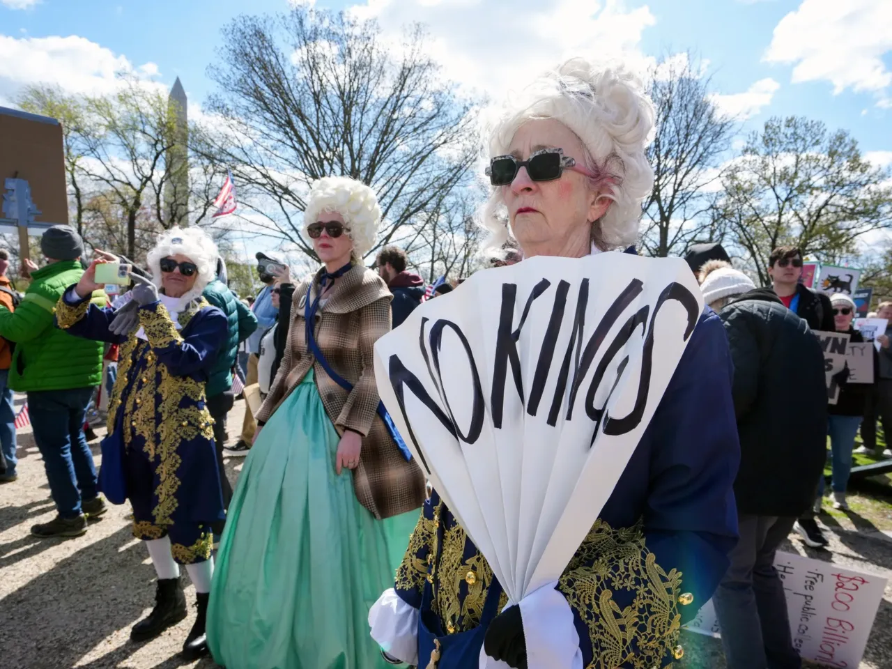 Demonstrators in costumes stand along the National Mall in Washington, DC.