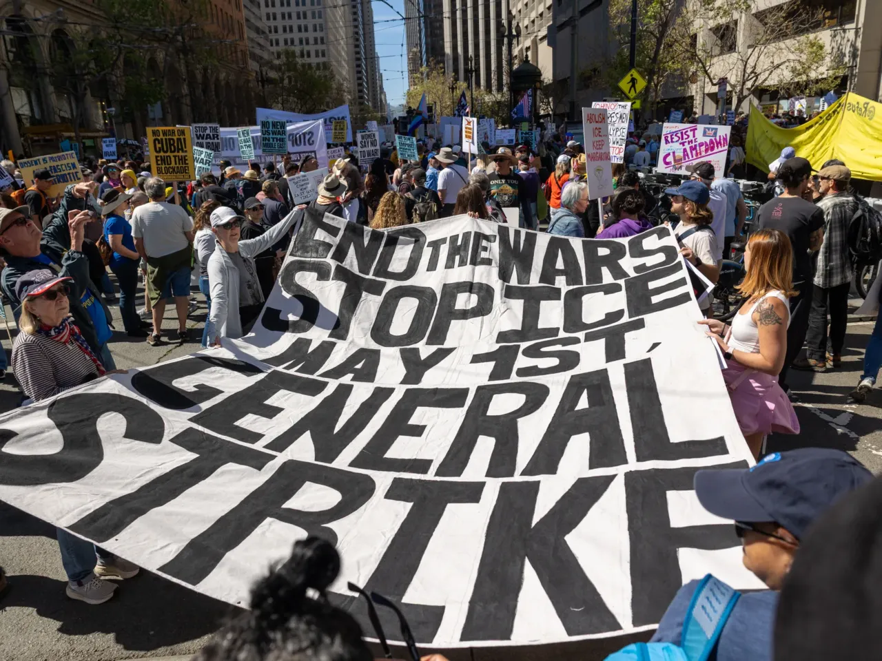 Protesters hold a banner reading "End the wars, stop ICE, general strike" at Embarcadero Plaza in San Francisco.