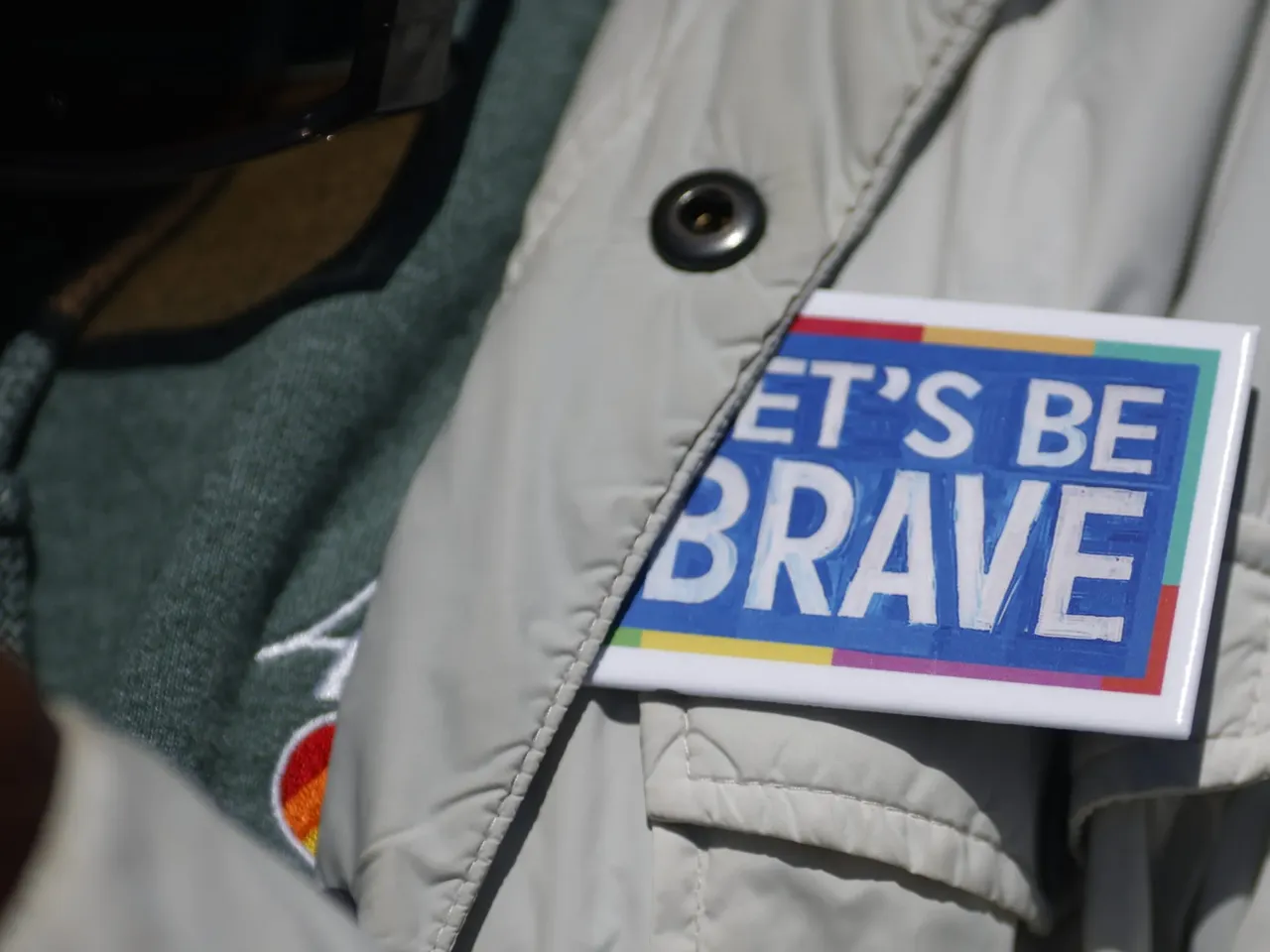 A protestor wears a "Let's be brave" pin at a rally in Richmond, Virginia.