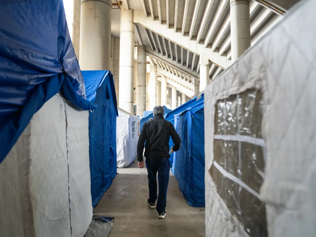 After Israel's invasion, many in southern Lebanon worry they'll never go home 3 Mustafa Alloush walks between tents at a stadium where thousands of displaced people are sleeping in Beirut after fleeing their homes during the invasion.