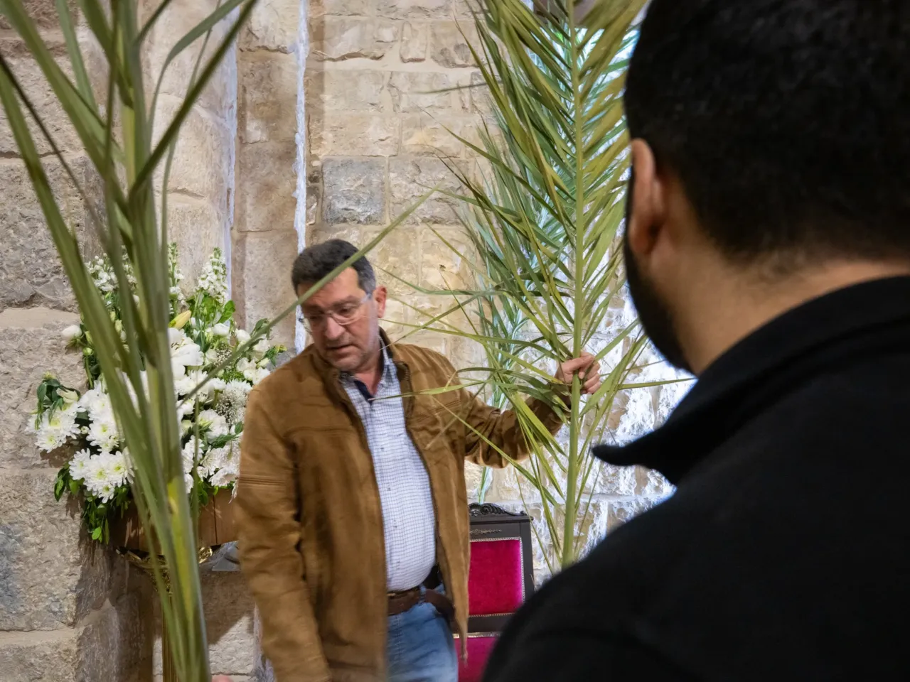 'Not our war' say Christians under siege this Easter, as Israel invades south Lebanon 1 Naim Rouhaim, whose brother is the parish priest, helps to set up palms at St. Maron church, the evening before Palm Sunday.