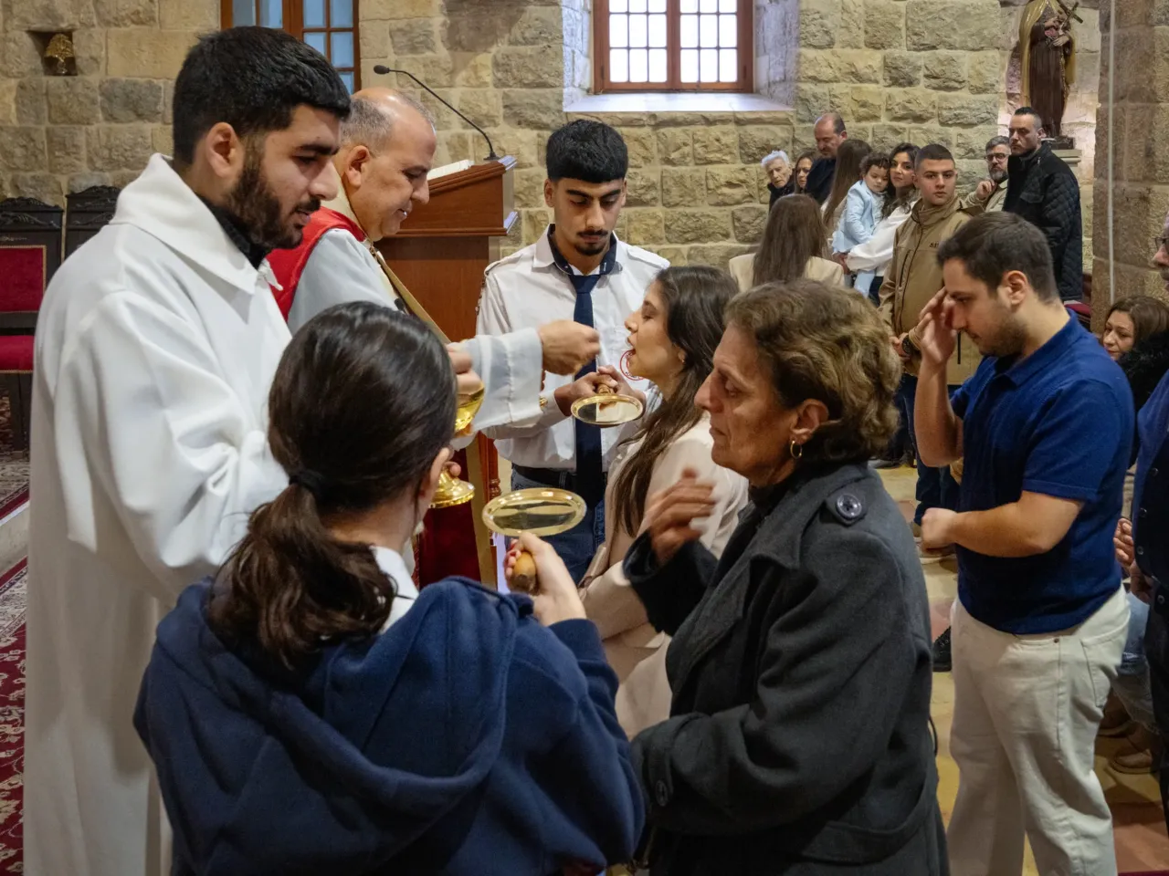 'Not our war' say Christians under siege this Easter, as Israel invades south Lebanon 3 Members of the St. Maron congregation receive communion on Palm Sunday.