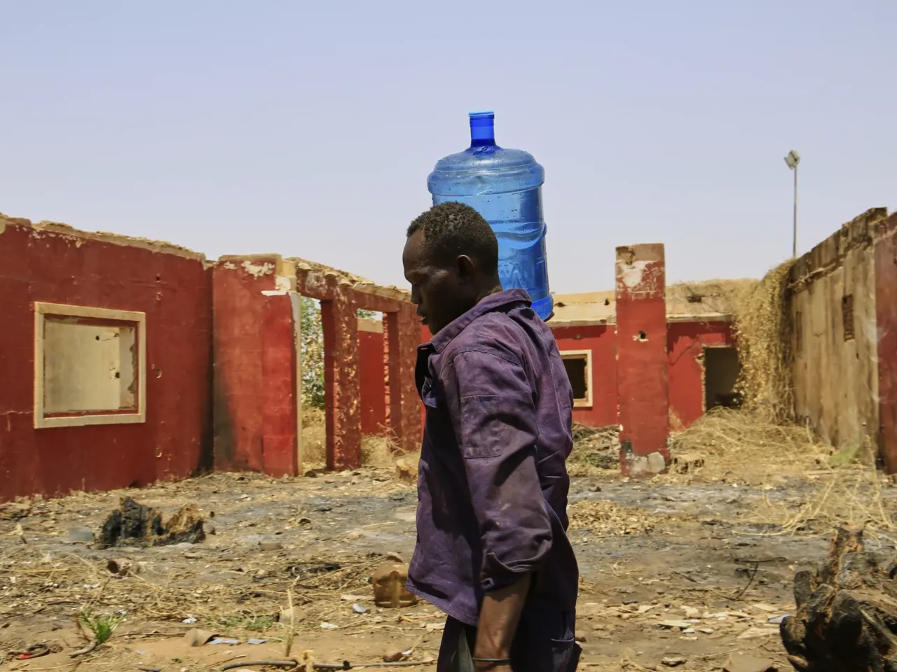 'Humiliated, broken, powerless': Sudan enters fourth year of war 3 A man carries a water container past a building damaged during the civil war at a distribution point due to water outages in Khartoum, Sudan, Sunday, May 25, 2025.